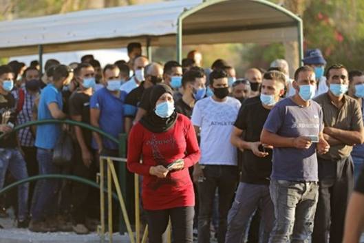Travailleurs palestiniens  un poste de contrle pour entrer  Jrusalem.  MENAHEM KAHANA / AFP