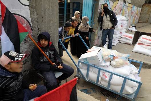 Arrive daide alimentaire fournie par lUNRWA, le 21 fvrier 2021, dans un camp de rfugis de Gaza.  Majdi Fathi. NurPhoto via AFP